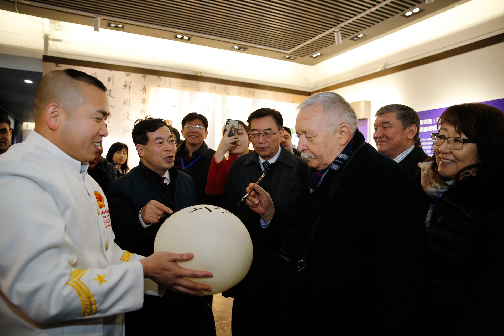 图为上海合作组织秘书处代表弗拉迪尔·扎哈罗夫先生在面气球上题字.