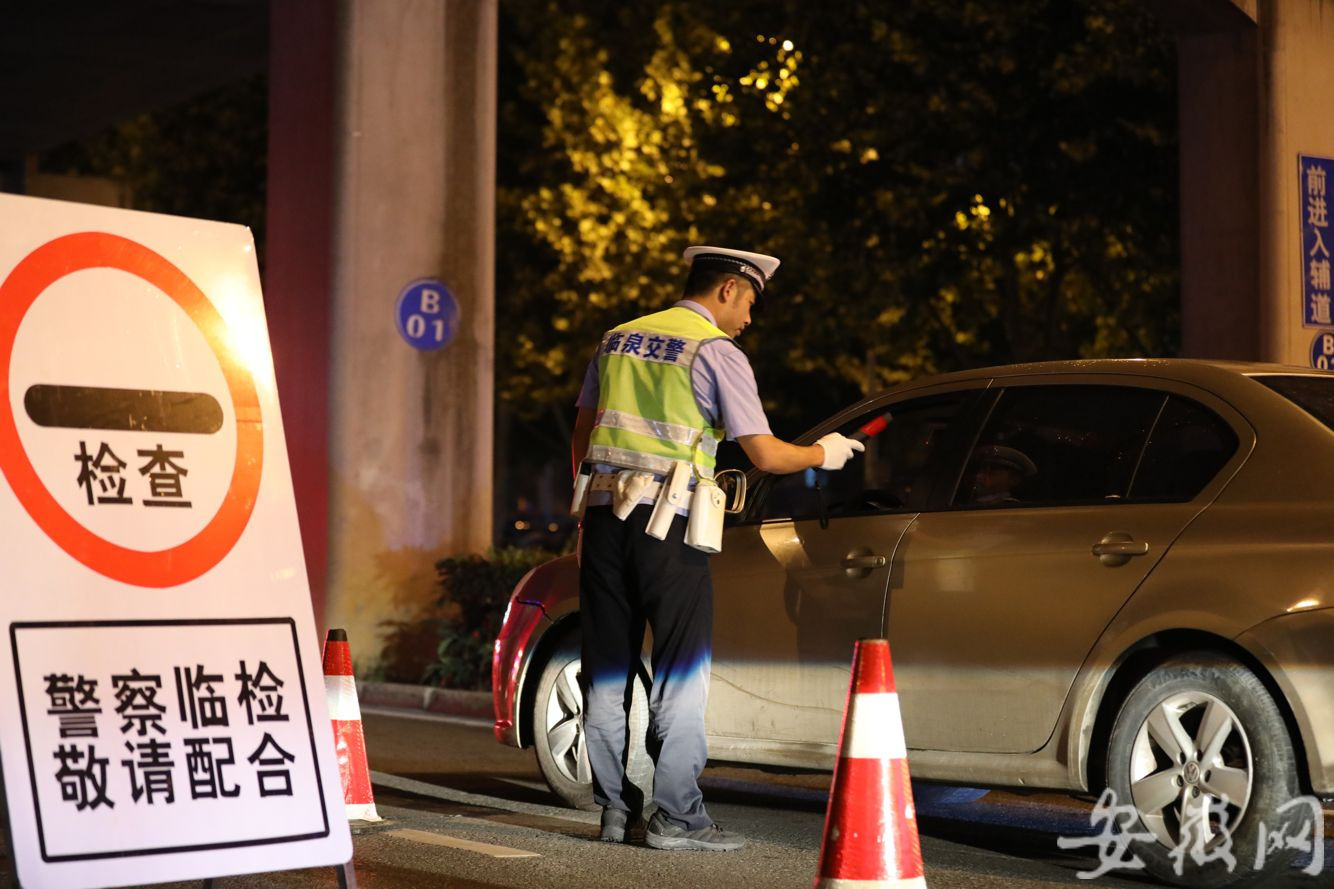 公安局交通管理警察大队民警在合肥市包河区一处临时检查点冒雨查酒驾