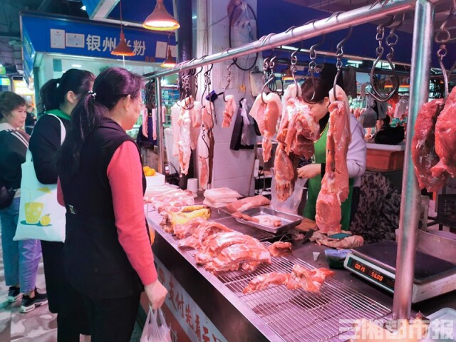 (11月19日上午,市民正在菜市场挑选猪肉.顾荣 摄)