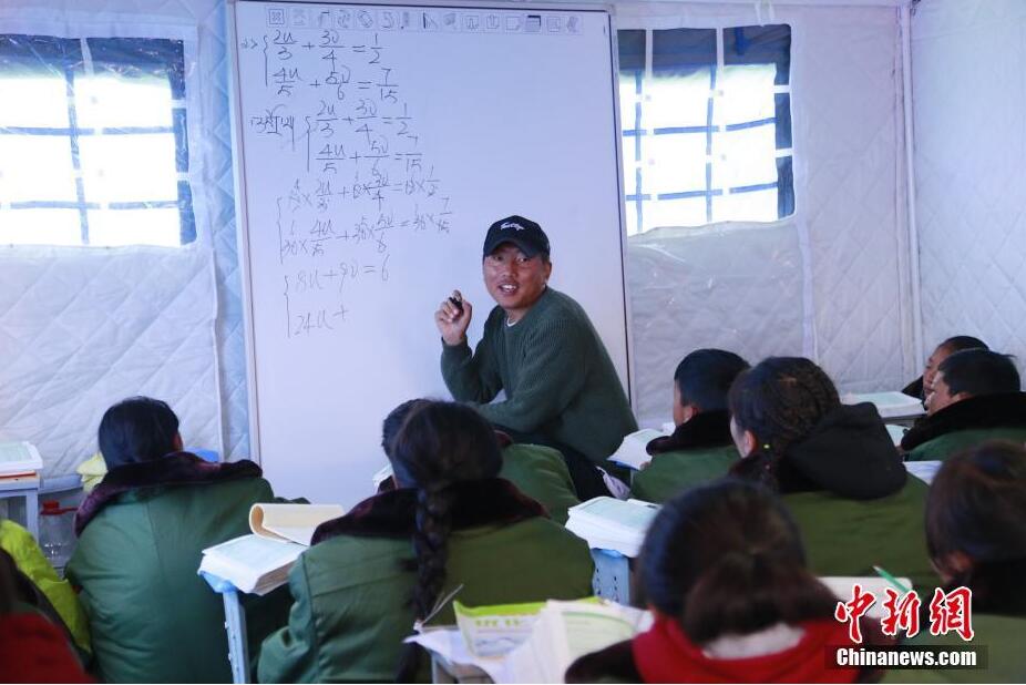 5月24日,玛多县民族寄宿制中学的老师在帐篷教室内讲课.