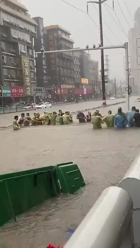 郑州暴雨商场积水多人被困 市民喊口号合力拉出被困者