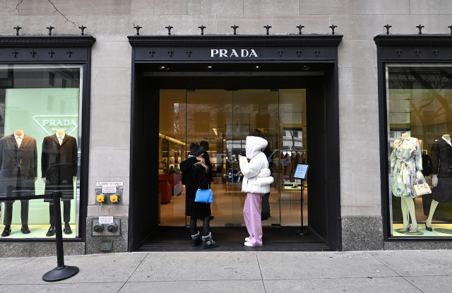 两名女性在外面等候进入纽约州纽约市的 prada madison avenue 精品店