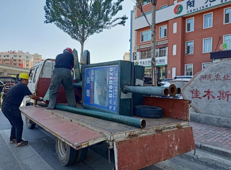 在广告牌拆除现场,工作人员设立安全警示牌设置了作业区域,安全员严守