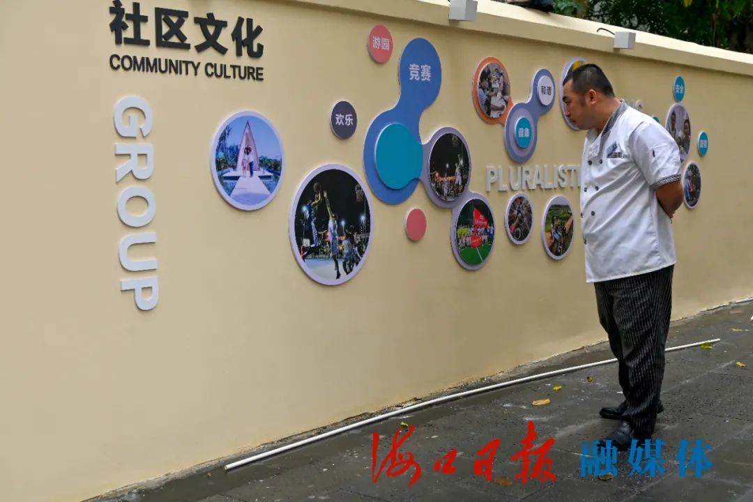 10月27日,海南省建筑设计院小区正在安装的社区文化墙,引来居民观看.