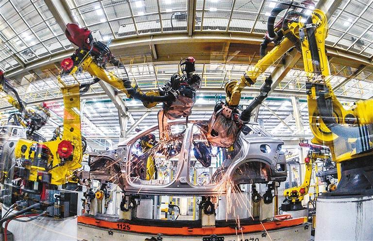 在西安比亚迪生产车间,机器人进行新能源汽车焊接作业.