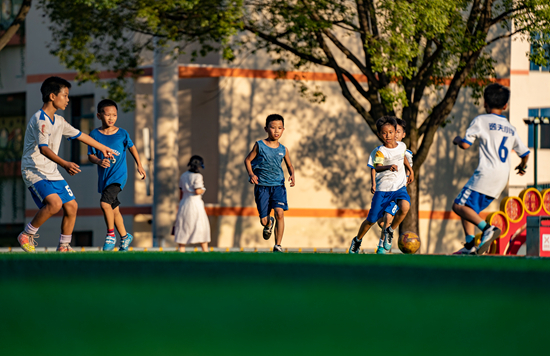 小学的小学生们在操场上进行丰富多彩的足球,篮球,羽毛球等运动项目