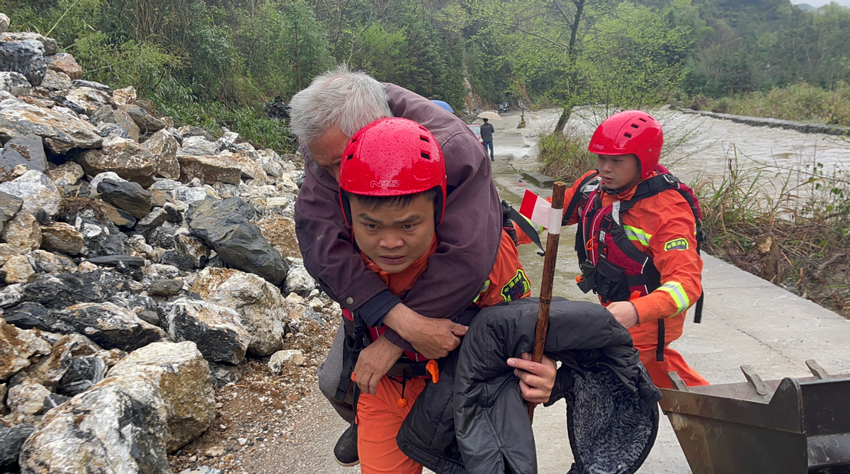 石台县消防救援大队副站长退役军人罗永涛背着仙寓镇莲花村老人前往