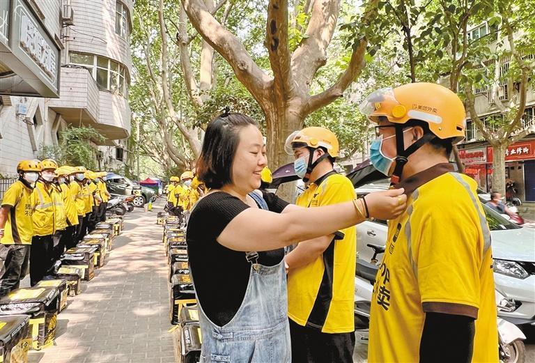 5月26日9时30分,在美团配送西安乐游原站的早会现场,站长苟琳(左)为