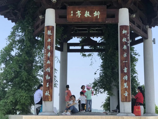 移步换景,只见他们静坐柳毅亭,时不时开怀大笑,与亲友尽情享受欢乐