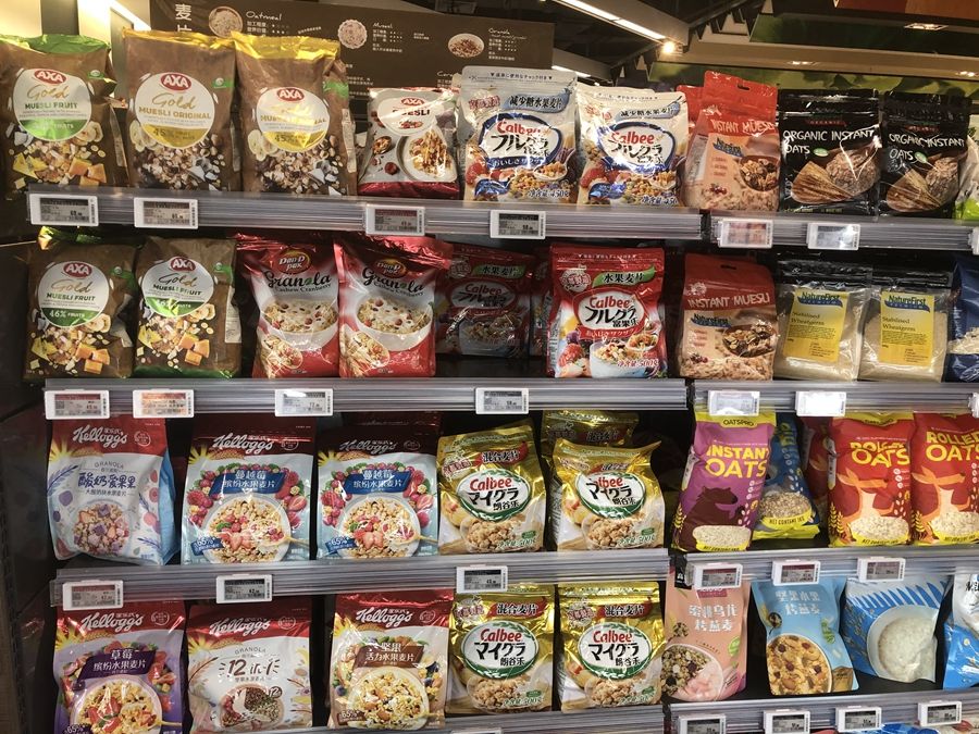 万象城超市内部货架上摆放的各类代餐食品,可以看到货品售卖后留下的