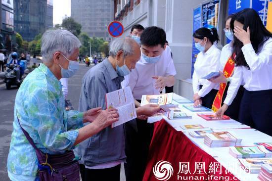 银行工作人员向老年人群众介绍防范电信诈骗知识