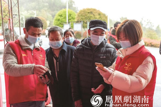 长沙县党员志愿者正在帮助参与核酸检测的群众扫描“场所码”。刘思源 摄