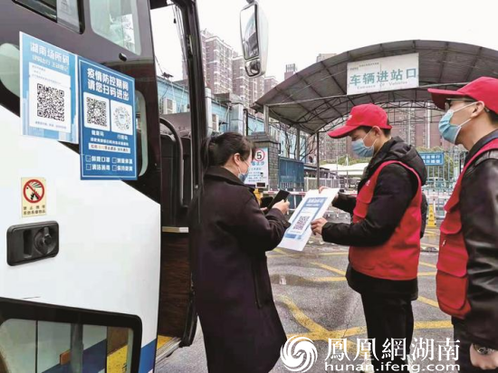 图为星沙汽车站工作人员及志愿者对每辆进站车辆执行严格防疫检查。陈晨 摄