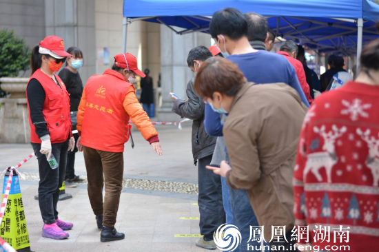 锦元社区志愿者在采样现场劝导居民保持一米线。