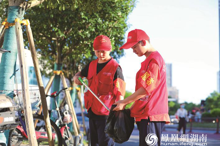 在长沙县的社区小巷、交通路口、景区景点等地，身穿红马甲的志愿者已成为这座城市一道道靓丽的风景线。 李杰 摄