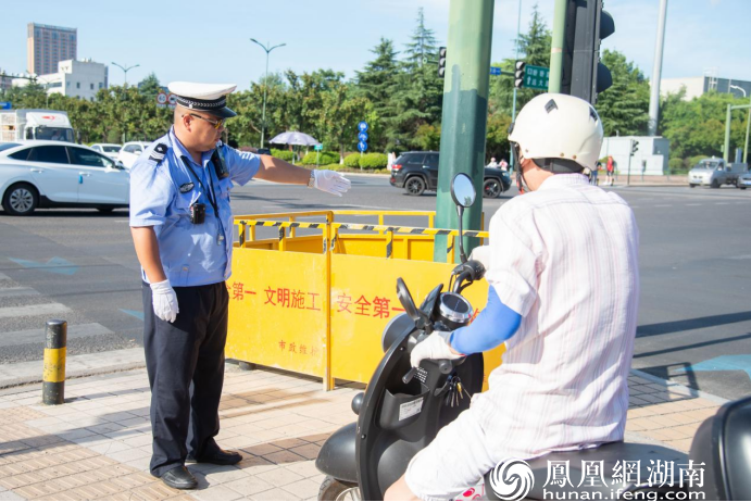 长沙县交警正在提醒市民按电动车标线行驶。