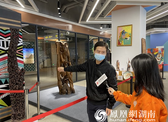 展馆负责人介绍非洲特色“家族树”工艺品。