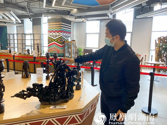 展馆负责人介绍乌木制成的工艺品。
