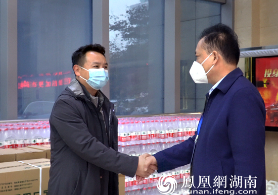 汪泽云（右）接受德成建设集团董事长沈洋的捐赠物资