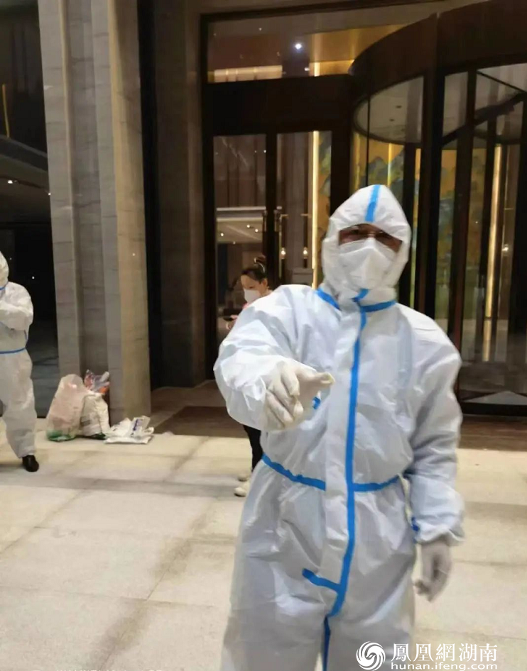 学校负责人廖利平带头穿上防护服送物资