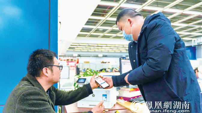 货车司机徐永龙（右）在工作人员的指导下，现场学习线上平台操作。梁焕鑫 摄