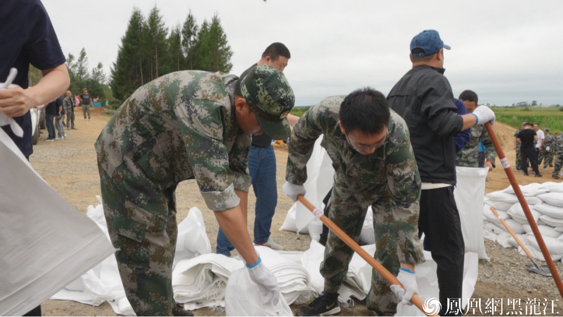 (机关干部在防汛一线装沙袋处置风险点)
