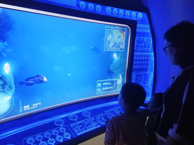 小朋友观众正在操作“蛟龙号”载人深潜器模型