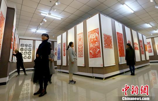图为镇原县文化馆内展出的精美剪纸作品，吸引众多爱好者前来参观。　高展摄