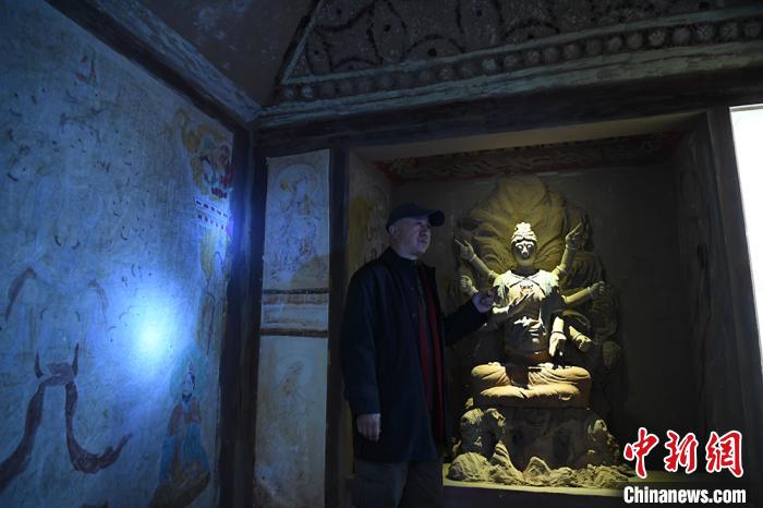 图为许林介绍洞窟壁画及佛头复原过程。　魏建军摄