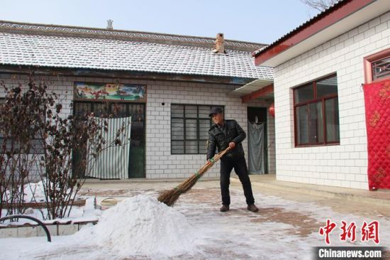 1月21日，贾海峰清扫院子里的积雪。　盘小美摄