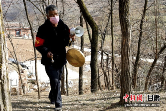 图为甘肃陇南西和县刘集村“银发志愿者”徒步在较偏僻的居住点敲锣宣传防疫知识。吕宏摄