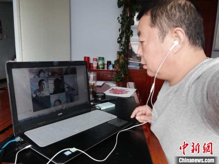 非物质文化遗产丰宁满族剪纸市级代表性传承人李金民通过网络给村民们授课。　张艳玲摄