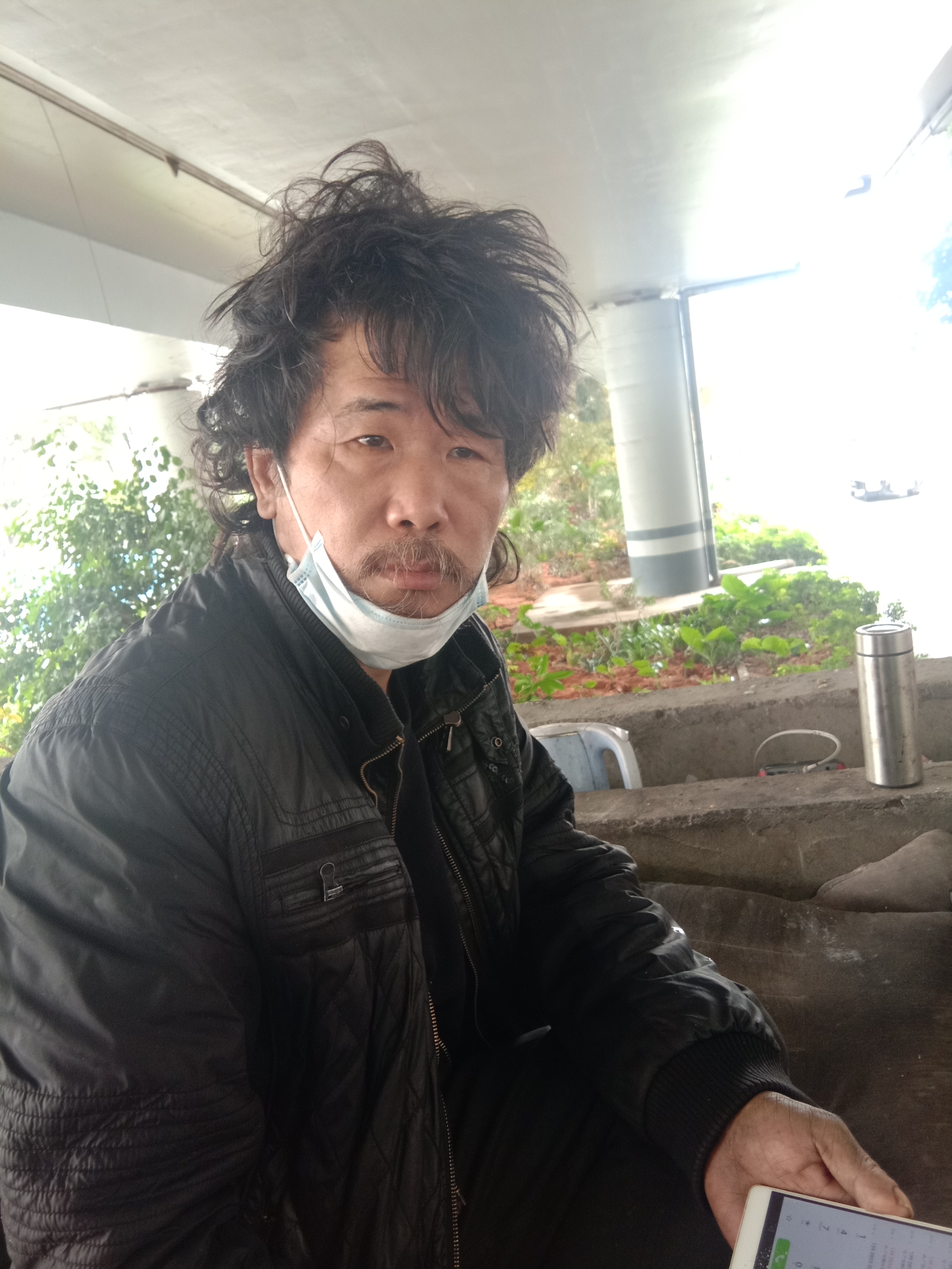 他和同伴在深圳宝安区一座立交桥下的垃圾房顶上发现了这名流浪男子
