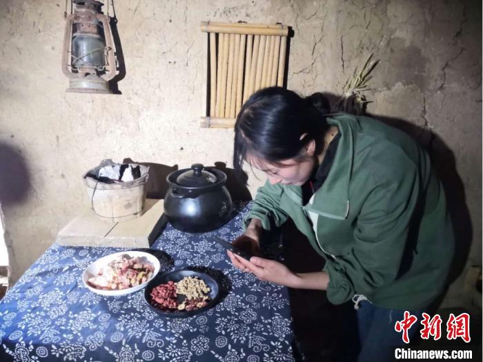 图为宕昌磨河坝村农家女，用手机录制烹饪“山味”的视频，与生活在都市的网友们分享。　后孝贤摄