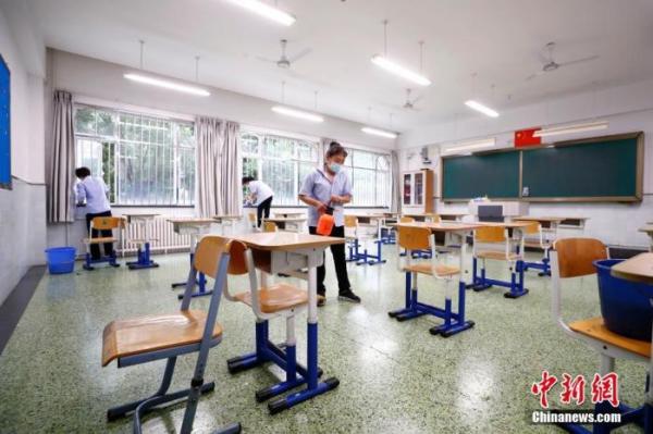 7月3日，北京十二中保洁人员对考场及走廊进行清扫、消毒。中新社记者富田摄