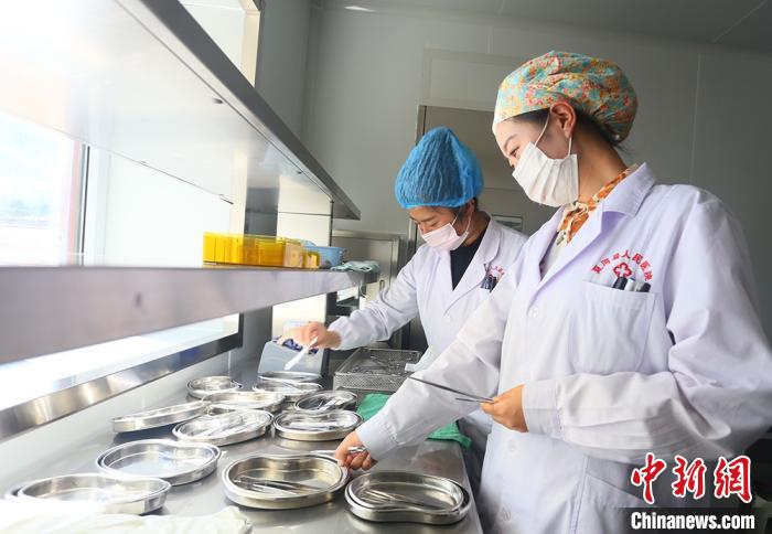 7月下旬，夏河县人民医院医生进行手术用具的消毒清洁。　高展摄