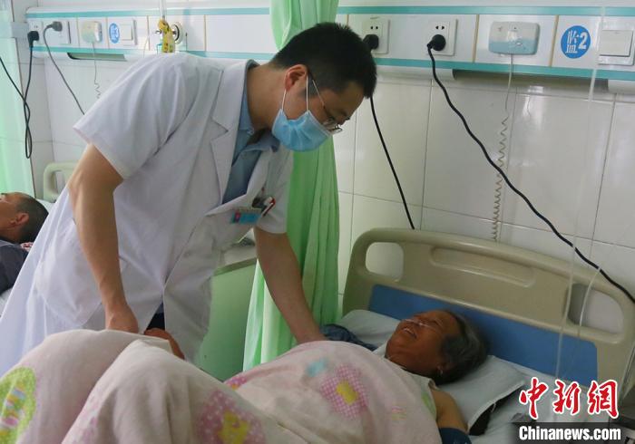 图为静宁县人民医院胸痛中心心内科主任韩飞查看患者情况。　高展摄