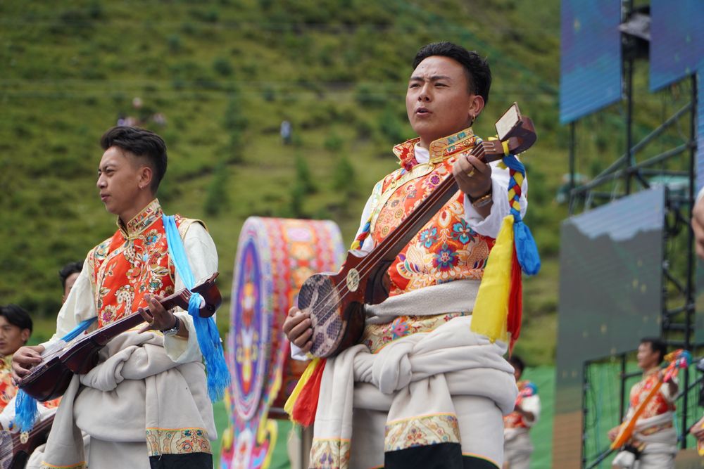 ↑8月12日，演员在开幕式上表演民族歌舞。