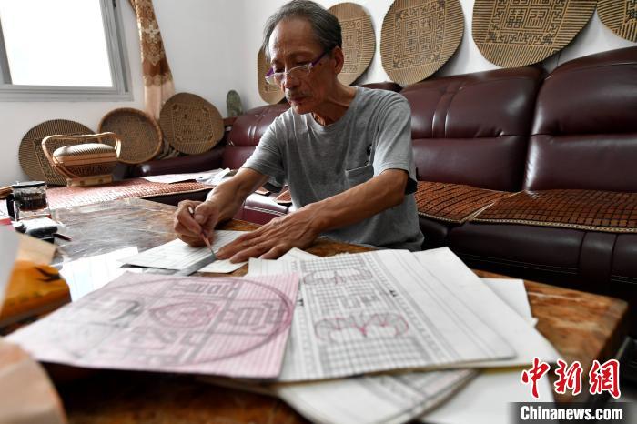 陈建德正在用铅笔做设计图纸。