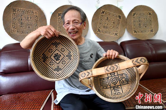 陈建德展示编制的竹制品。叶秋云摄