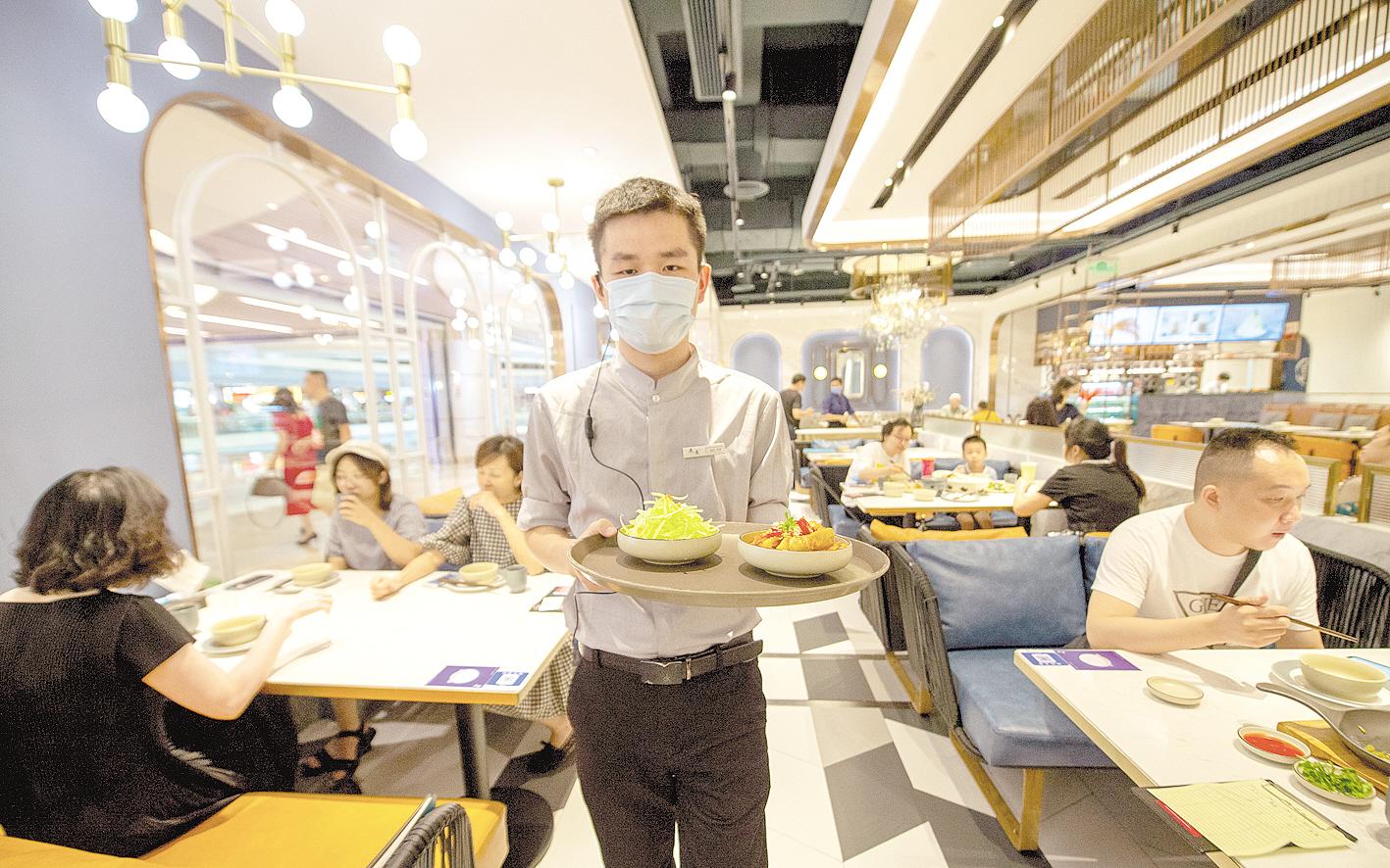 9月2日,武汉国际广场鹿港小镇餐厅,服务员为顾客盛上小份菜品.