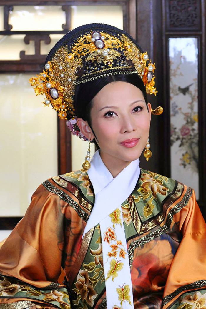 她的脚指头,另一只手拿着指甲刀,非常认真的坐在地上为"娘娘"剪脚指甲