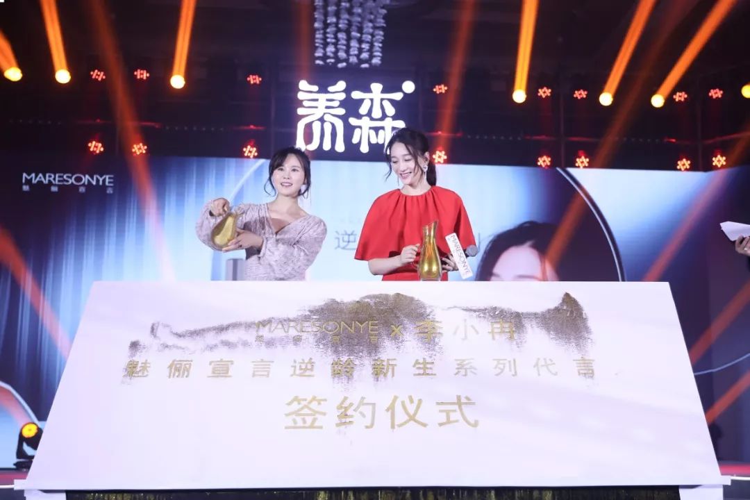 携手李小冉一起共同完成了品牌代言的鎏金沙签约仪式