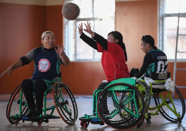 11月10日,西藏轮椅篮球队球员巴桑卓玛(中)在比赛中投篮