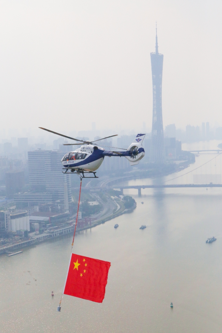 10月1日,广州市公安局警航支队出动两架警用直升机进行悬挂国旗编队