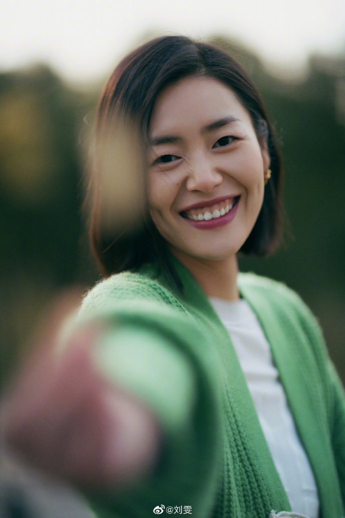 "照片里,刘雯身穿绿色毛衣开衫,在阳光照耀下露出明媚笑容,如同寒冷