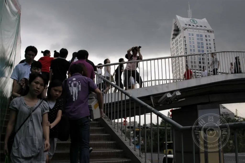 2010年,深圳市深南大道上一场暴风雨即将来临,忙着赶路的年轻人和
