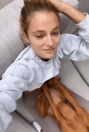 视频中乐福的爱犬"正襟危坐"在kate bock的肚子上,表情一脸不高兴