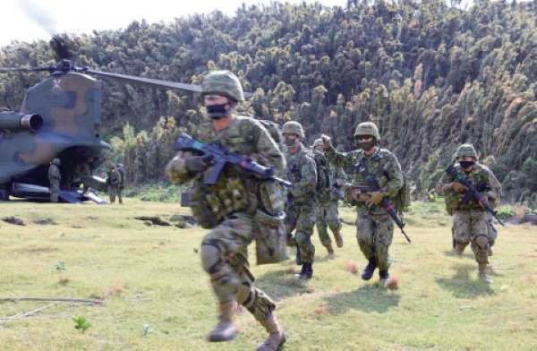 日本自卫队员在演习中搭乘直升机登陆“夺岛”。