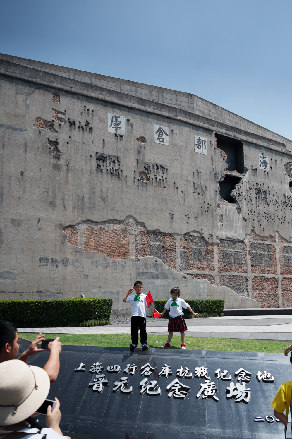 上海四行仓库晋元纪念广场。家长在布满弹孔的四行仓库西墙前为孩子拍照留念。